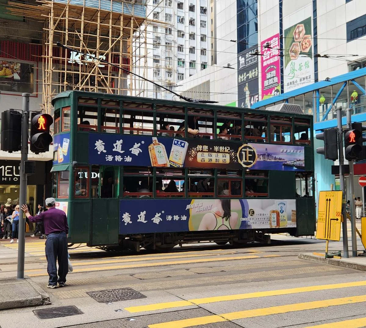 Green double-decker Hong Kong tram crossing a street in Causeway Bay