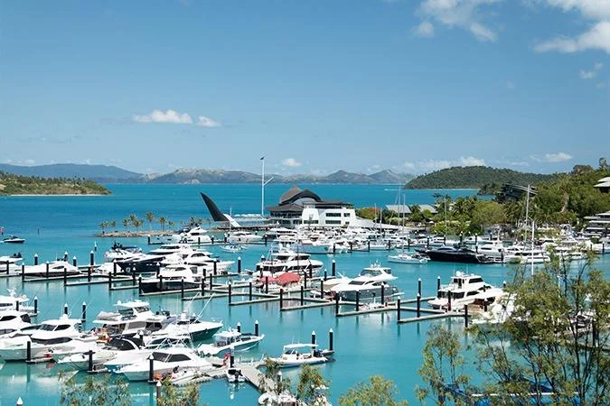 Yachts moored at the Hamilton Island marina in front of the yacht club building